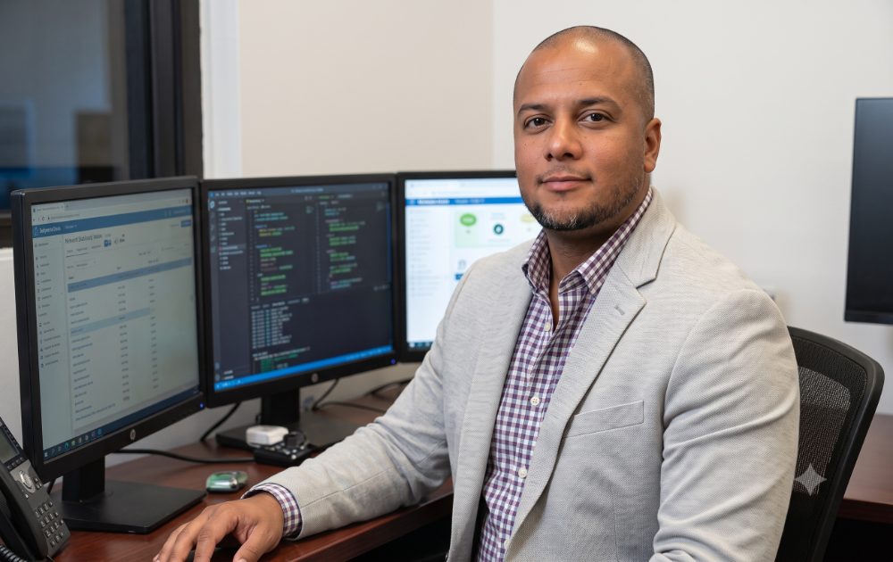 IT manager rolling out a cart of new PCs and monitors